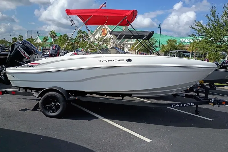 Slide: The Image of 2027 Tahoe T18 boat with red canopy on trailer in parking lot. - 1