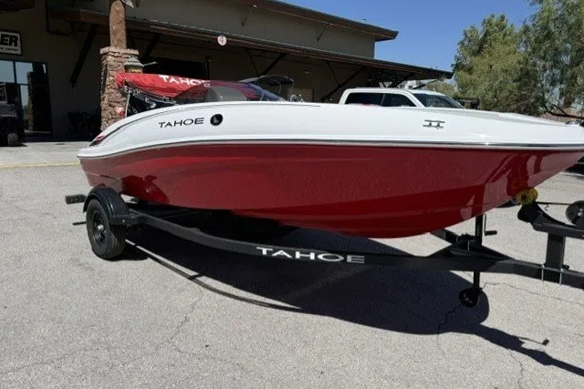 Slide: The Image of 2027 Tahoe T16 boat with red and white design on a trailer in a sunny outdoor setting. - 1