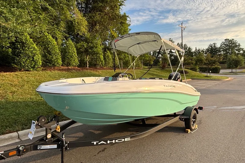 Slide: The Image of 2027 Tahoe T18 boat on trailer, parked outdoors, with green hull and canopy. - 2