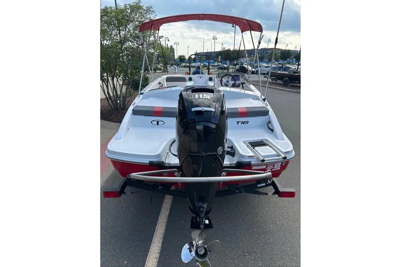 Slide: The Image of 2027 Tahoe T18 boat with outboard motor, parked on pavement under a cloudy sky. - 3