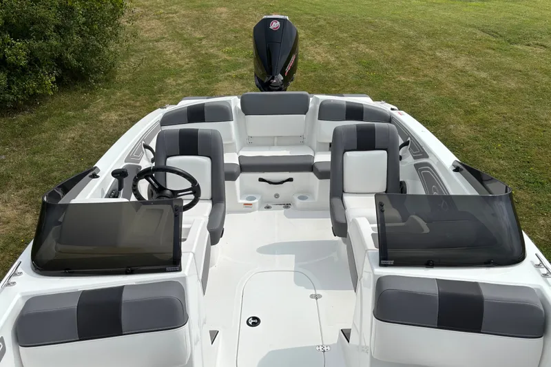 Slide: The Image of 2027 Tahoe T21 boat interior with seating and steering wheel on grassy background. - 5