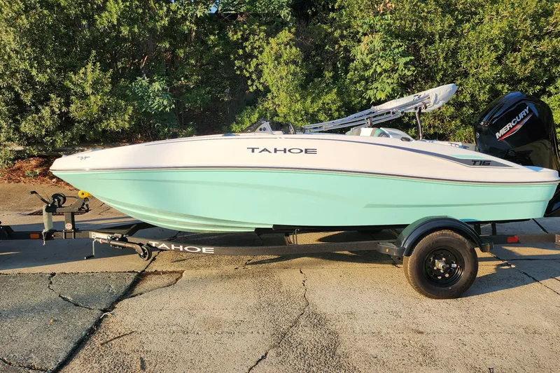 The Image of 2027 Tahoe T16 boat on trailer, light blue hull, parked outdoors. - 0
