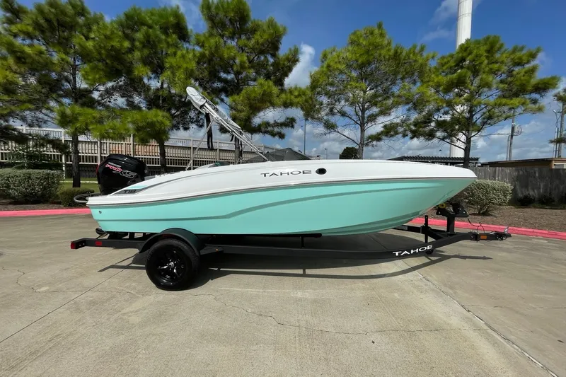 Slide: The Image of 2027 Tahoe T18 boat on trailer, mint green hull, parked outdoors under blue sky. - 3