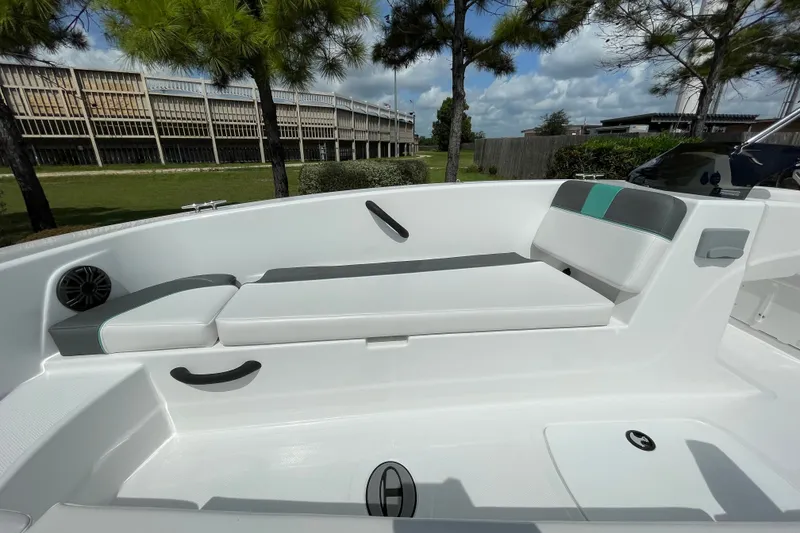 Slide: The Image of 2027 Tahoe T18 boat interior with cushioned seating and speaker, surrounded by trees. - 8