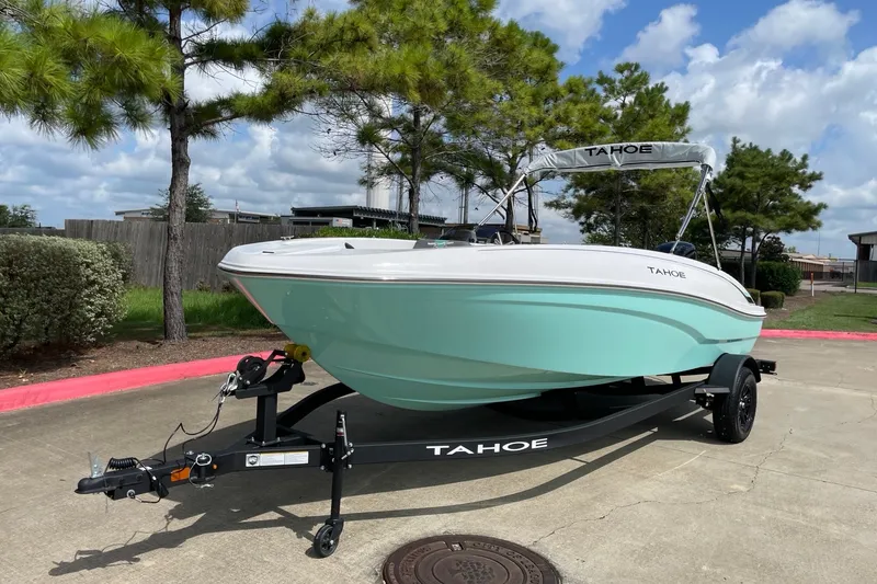 Slide: The Image of 2027 Tahoe T18 boat on trailer, parked outdoors under a cloudy sky. - 1