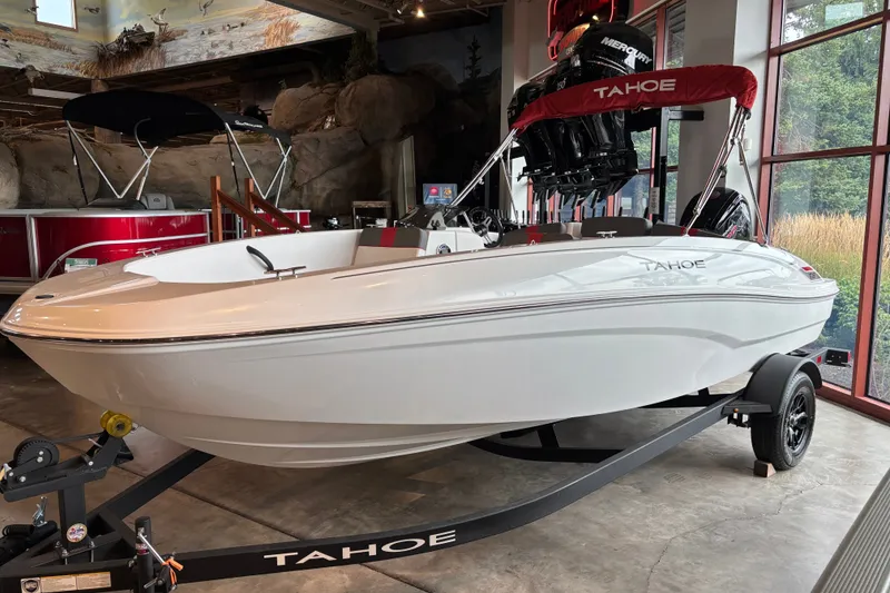 The Image of 2027 Tahoe T18 boat on display in showroom, featuring sleek white design and red canopy. - 0