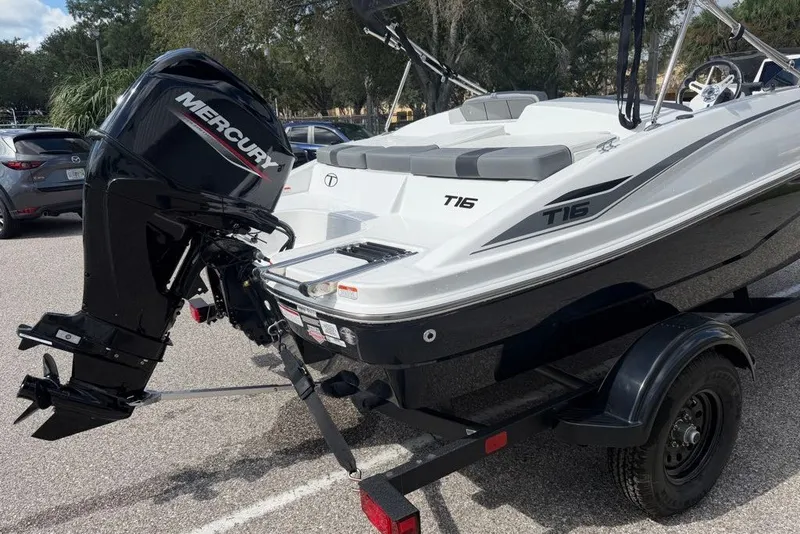 Slide: The Image of 2027 Tahoe T16 boat with Mercury engine on a trailer in a parking lot. - 6