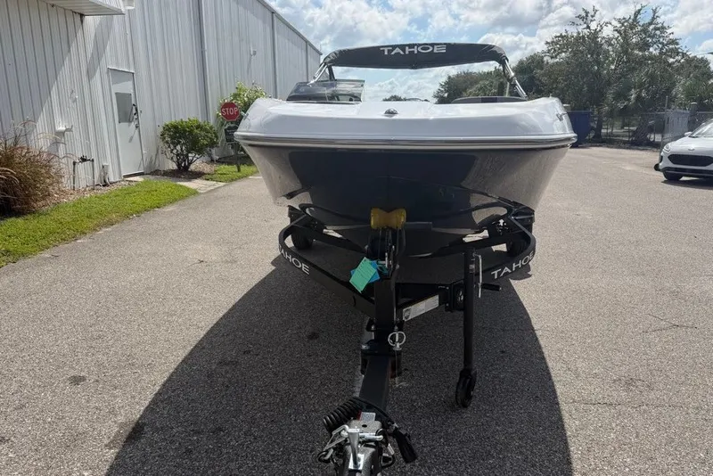 Slide: The Image of 2027 Tahoe T16 boat on trailer, parked outdoors under a partly cloudy sky. - 1