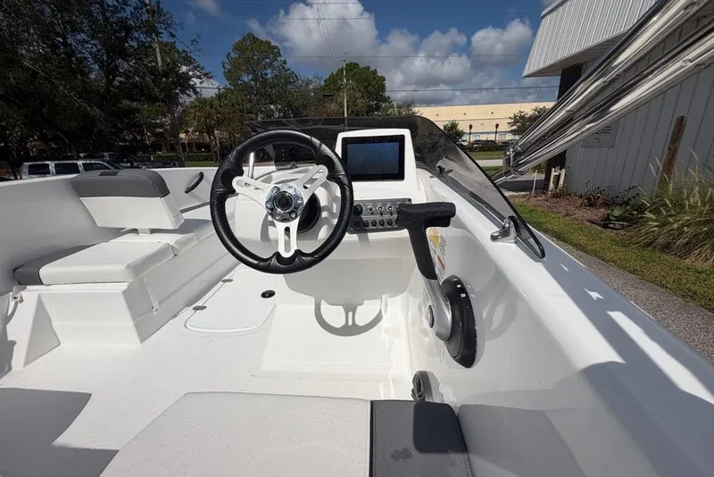 Slide: The Image of 2027 Tahoe T16 boat interior with steering wheel and control panel under a clear sky. - 66