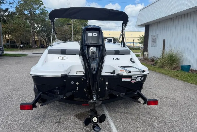 Slide: The Image of 2027 Tahoe T16 boat with 60 HP engine on a trailer, parked outdoors. - 5