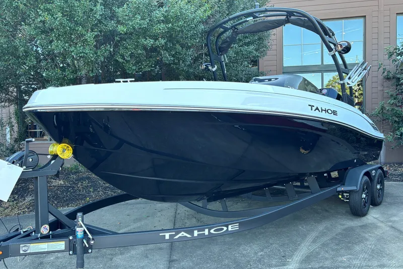 The Image of 2027 Tahoe T21 boat on trailer, sleek design, parked outdoors. - 0