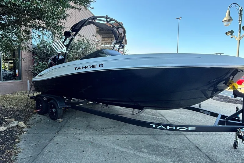 Slide: The Image of 2027 Tahoe T21 boat on trailer, parked outdoors near a building. - 4