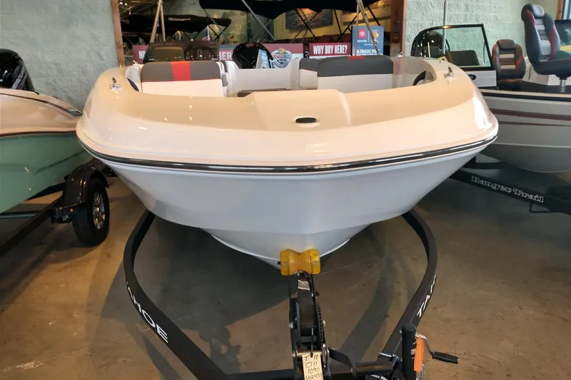 Slide: The Image of 2027 Tahoe T18 boat on trailer in showroom, featuring sleek white design. - 1
