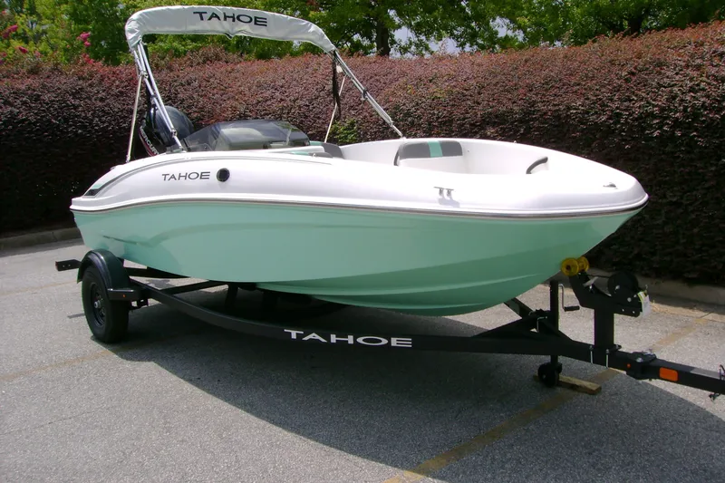 Slide: The Image of 2027 Tahoe T16 boat on trailer, mint green hull, parked outdoors. - 2
