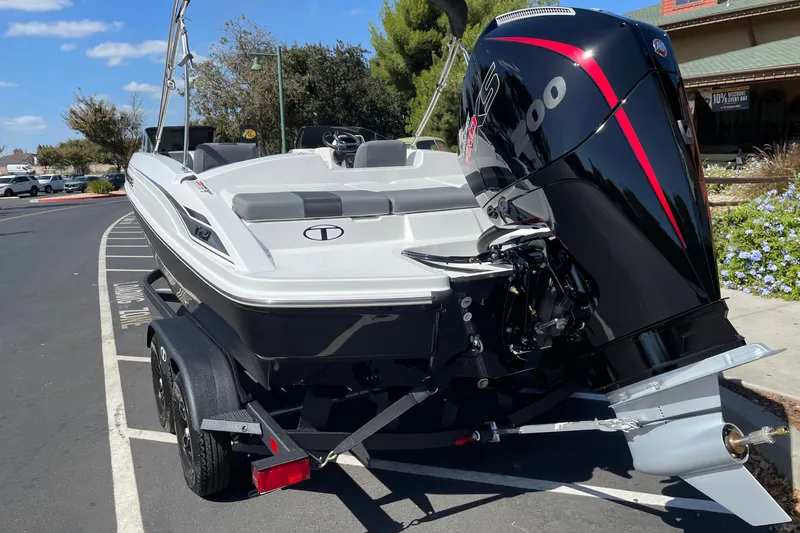 Slide: The Image of 2027 Tahoe T21 boat on trailer with powerful outboard motor, parked outdoors. - 4