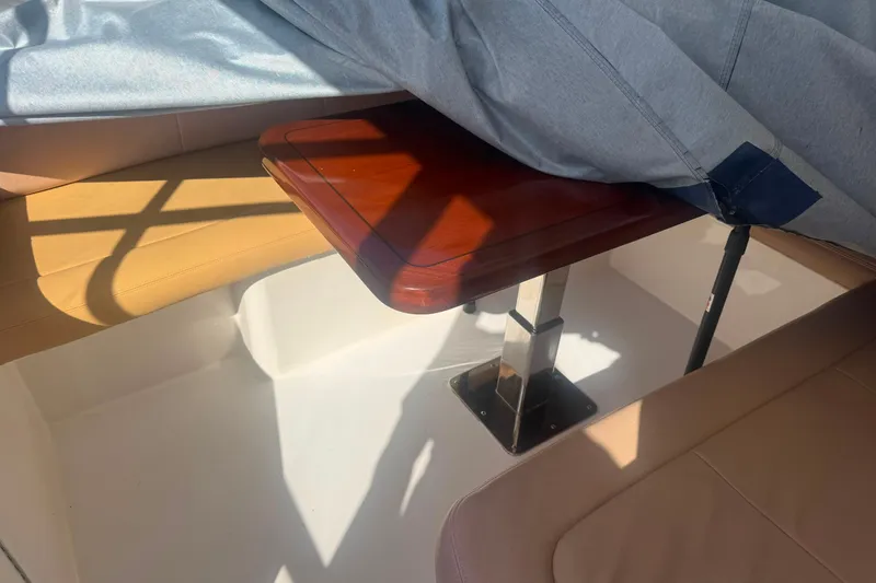 Slide: The Image of Interior of a 2003 Bertram 450 Convertible with wooden table and beige seating. - 14