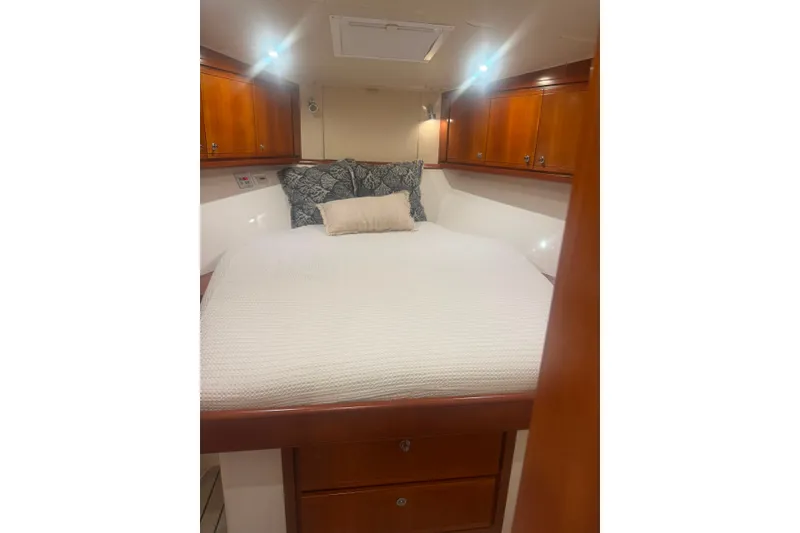 Slide: The Image of Interior cabin of 2003 Bertram 450 Convertible yacht with cozy bed and wooden cabinets. - 7