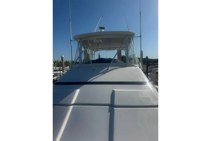 Slide: The Image of 2003 Bertram 450 Convertible yacht docked under clear blue sky. - 4