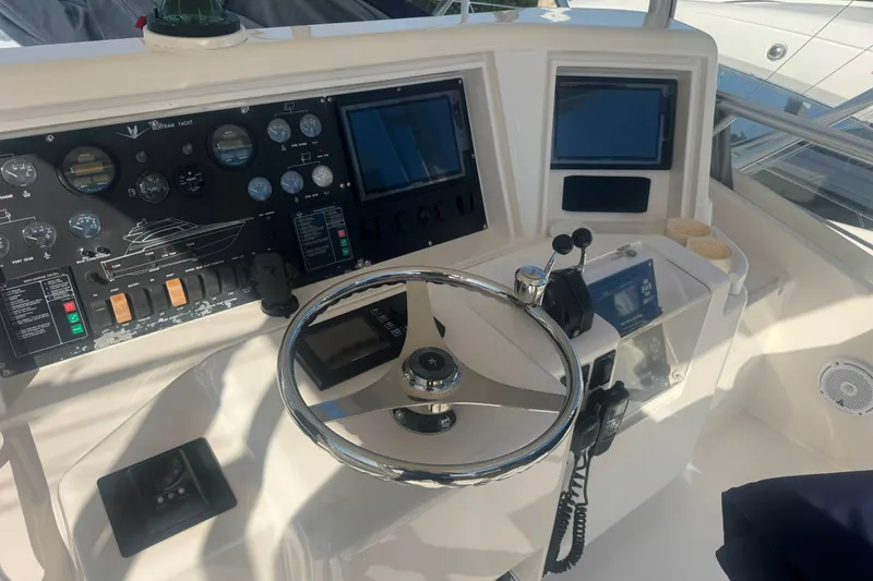 Slide: The Image of Cockpit of 2003 Bertram 450 Convertible yacht with steering wheel and control panels. - 9