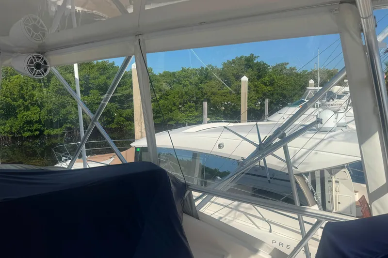 Slide: The Image of Bertram 450 Convertible yacht docked near lush greenery, 2003 model. - 6