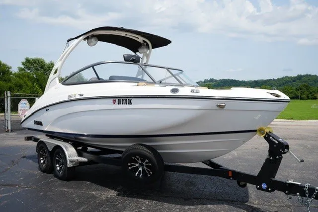 Slide: The Image of 2022 Yamaha 212 boat on trailer, parked outdoors with scenic background. - 3