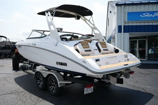 Slide: The Image of 2022 Yamaha 212 boat on trailer outside dealership, rear view. - 7