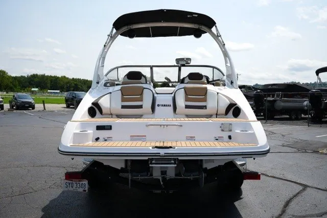 Slide: The Image of 2022 Yamaha 212 boat, rear view, parked on asphalt, showcasing seating and swim platform. - 6