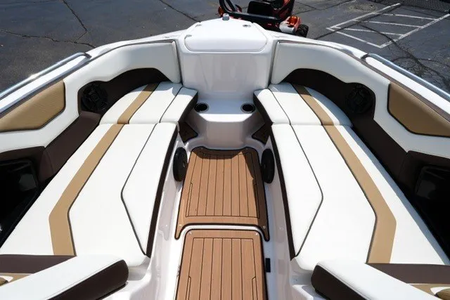 Slide: The Image of 2022 Yamaha 212 boat interior with tan and white seating, wood-style flooring. - 9