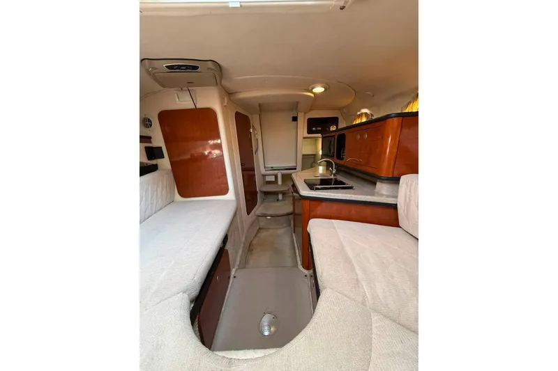 Slide: The Image of Interior of 2007 Sea Ray Sundancer 260, featuring cozy seating and compact kitchenette. - 12
