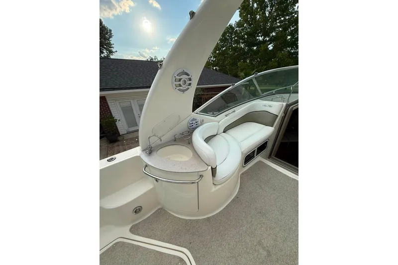 Slide: The Image of 2007 Sea Ray Sundancer 260 boat interior with seating and sink under a sunny sky. - 19