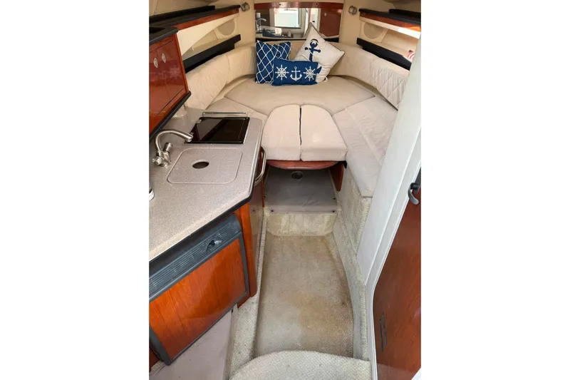Slide: The Image of Interior of 2007 Sea Ray Sundancer 260 with cozy seating and compact kitchenette. - 13