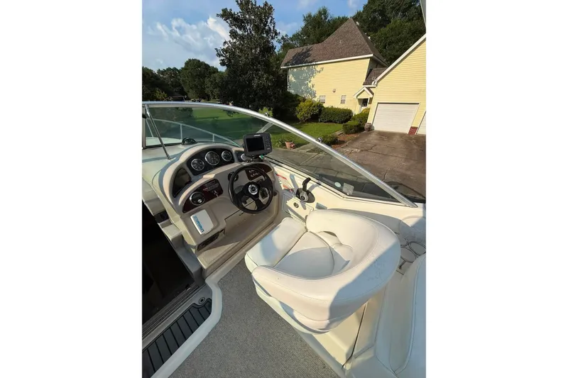 Slide: The Image of 2007 Sea Ray Sundancer 260 helm with steering wheel and gauges, parked in driveway. - 17