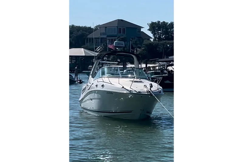 Slide: The Image of 2007 Sea Ray Sundancer 260 boat docked on a sunny day, with waterfront houses in the background. - 3