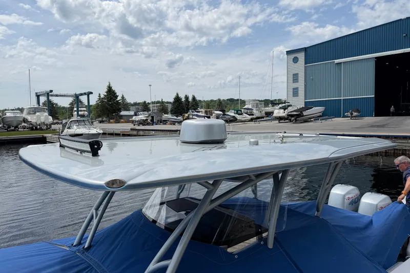 Slide: The Image of 2022 Nor-Tech 340 Sport boat docked near a marina with blue cover. - 32