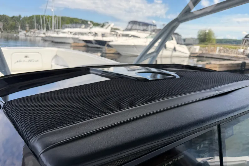 Slide: The Image of 2022 Nor-Tech 340 Sport boat dashboard with textured black finish, docked at marina. - 21