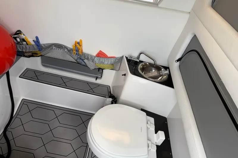 Slide: The Image of 2022 Nor-Tech 340 Sport boat interior with toilet and sink. - 24