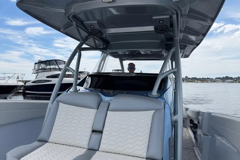 Slide: The Image of 2022 Nor-Tech 340 Sport boat interior with seating, docked near other boats. - 25