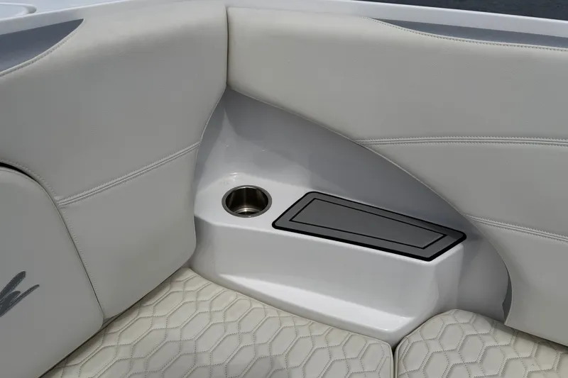 Slide: The Image of 2022 Nor-Tech 340 Sport boat interior with white cushioned seating and cup holder. - 28