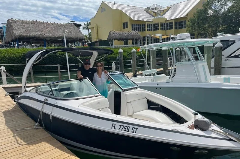 Slide: The Image of 2010 Regal 2500 Bowrider docked with two people onboard, sunny marina setting. - 1