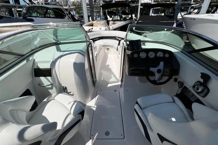 Slide: The Image of 2010 Regal 2500 Bowrider interior with sleek white seating and modern dashboard controls. - 2