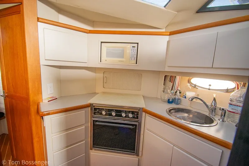 Slide: The Image of 1994 Carver 370 Aft Cabin Motor Yacht kitchen with stove, microwave, and sink. - 19