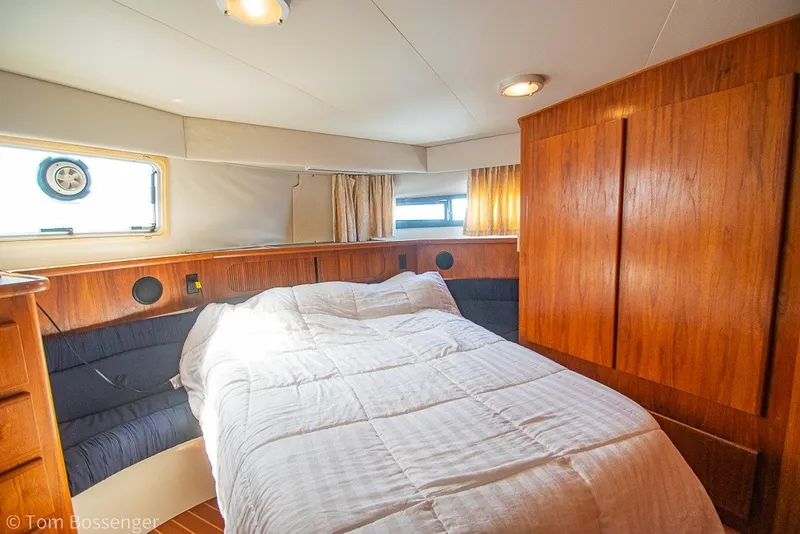 Slide: The Image of Cozy bedroom in 1994 Carver 370 Aft Cabin Motor Yacht with wood paneling and natural light. - 23