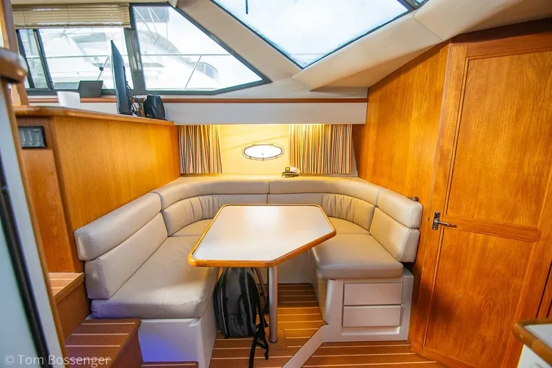 Slide: The Image of 1994 Carver 370 Aft Cabin Motor Yacht interior with cozy dining area and wooden accents. - 21