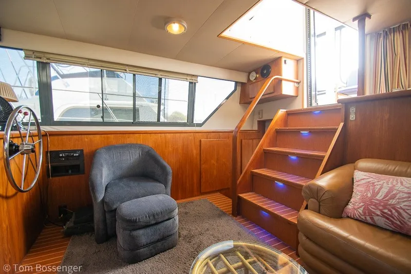 Slide: The Image of Interior of 1994 Carver 370 Aft Cabin Motor Yacht with cozy seating and wooden stairs. - 13