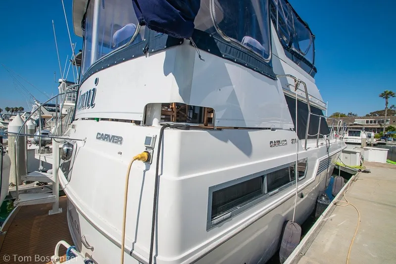 Slide: The Image of 1994 Carver 370 Aft Cabin Motor Yacht docked at marina under clear blue sky. - 5