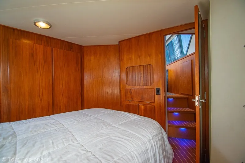 Slide: The Image of Interior of 1994 Carver 370 Aft Cabin Motor Yacht with wooden paneling and cozy bedding. - 25
