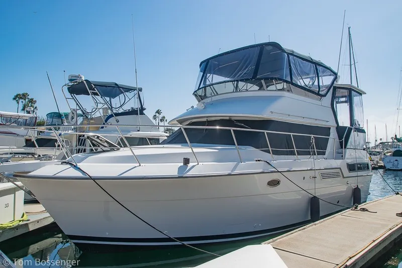 Slide: The Image of 1994 Carver 370 Aft Cabin Motor Yacht docked at marina under clear blue sky. - 2