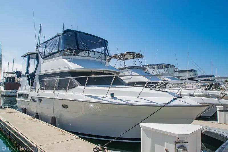 The Image of 1994 Carver 370 Aft Cabin Motor Yacht docked at marina under clear blue sky. - 1