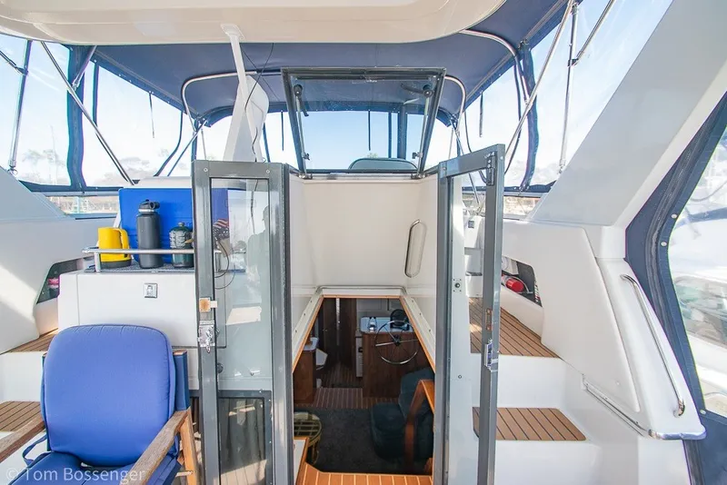 Slide: The Image of 1994 Carver 370 Aft Cabin Motor Yacht interior with blue seating and wooden accents. - 8