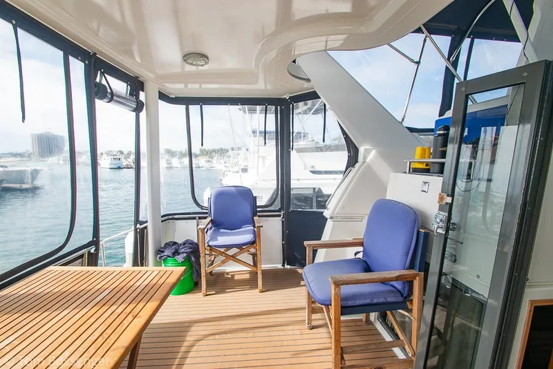 Slide: The Image of 1994 Carver 370 Aft Cabin Motor Yacht interior with seating and table, overlooking marina. - 34